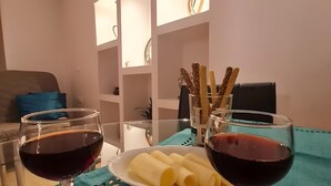 A dining table with two wine glasses, a plate of pasta, and a glass of water. - Maria's Heaven House - Old Town Apartment with Private Terrace, Wi-Fi & Air Conditioning (Rodos)