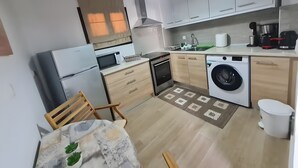 A compact kitchen with a refrigerator, microwave, oven, washing machine, and a sink. - Maria's Heaven House - Old Town Apartment with Private Terrace, Wi-Fi & Air Conditioning (Rodos)