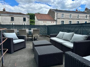 An outdoor patio with wicker furniture, including sofas and chairs, and a table. - 3-bedroom house, sleeps 8, Cordeliers (Parthenay)