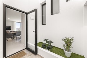 A modern interior with a glass door leading to a dining area, a small indoor garden, and a potted plant. - Villa Infinity Views 3 by Escape Home (Tahiche)