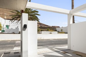A modern building with a white facade, a palm tree, and a road in the background. - Villa Infinity Views 3 by Escape Home (Tahiche)