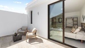 A modern outdoor living area with a sofa, a chair, and a coffee table. - Villa Infinity Views 4 by Escape Home (Tahiche)