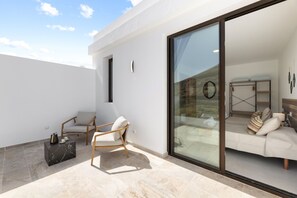 A modern outdoor living area with a sofa, a chair, and a coffee table. - Villa Infinity Views 4 by Escape Home (Tahiche)