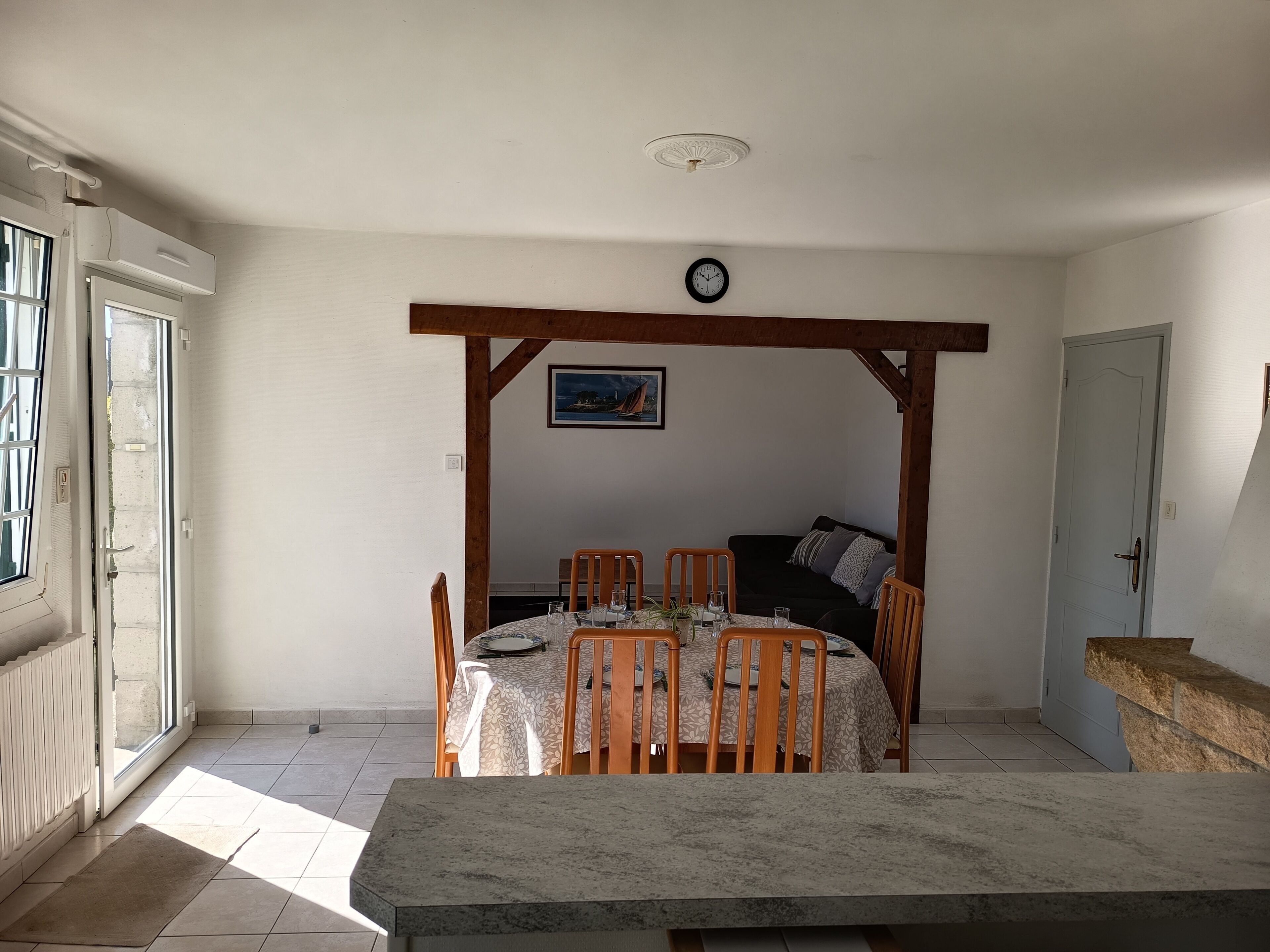 Un coin repas comprenant une table, des chaises, une horloge et un canapé.