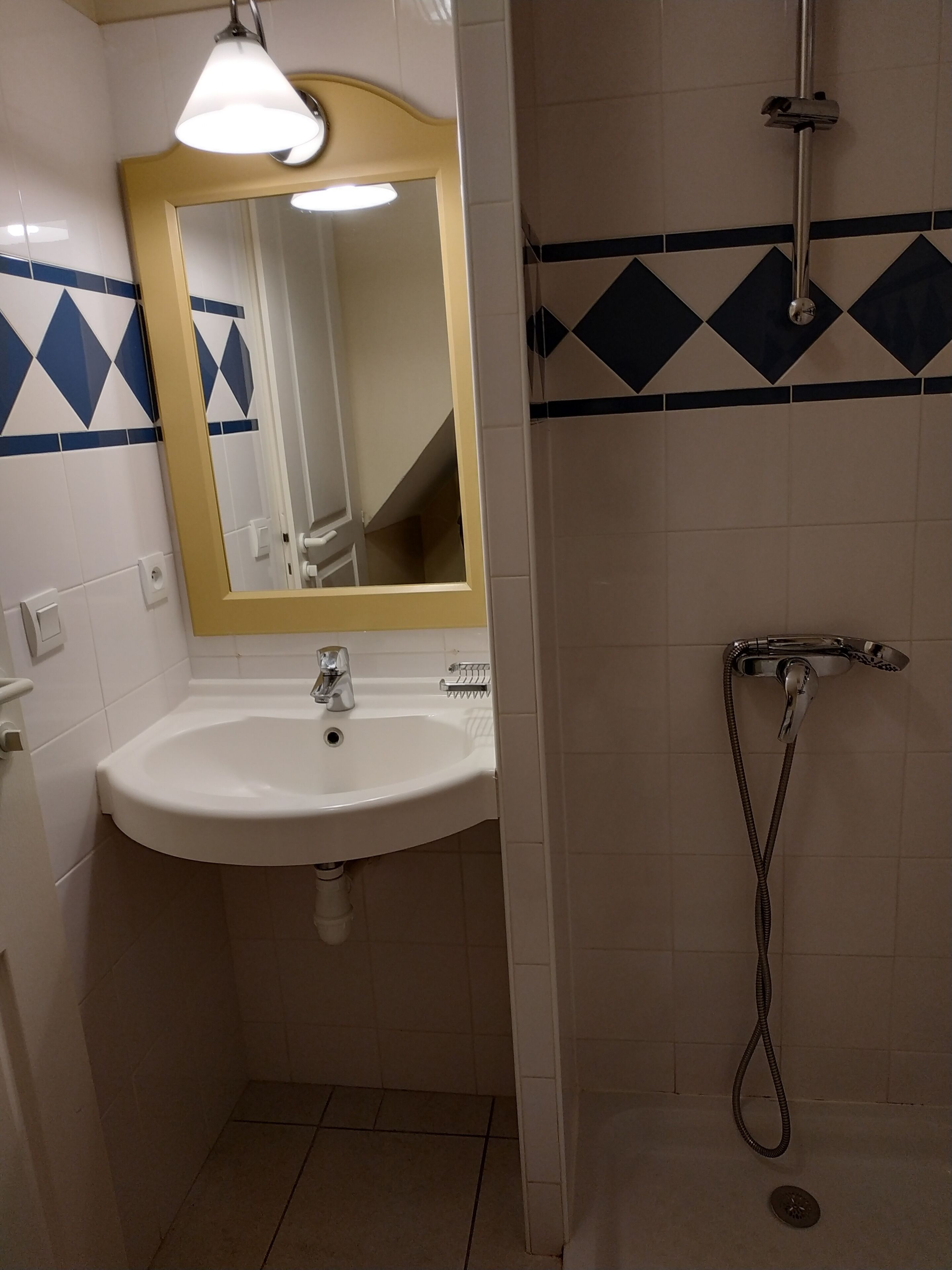 Une salle de bain avec un lavabo, un miroir et une douche.
