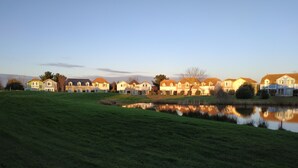 A row of houses with a pond in the foreground. - House Port Bourgenay 6-8 pers - 3 bdrms - pools/toboggans-Plage-Golf- Activities (Talmont-Saint-Hilaire)