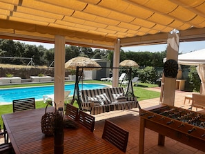 A covered outdoor area with a pool, lounge chairs, a foosball table, and a dartboard. - Casa Rural El Olivo in Ituero y Lama with Private Pool (Ituero y Lama)