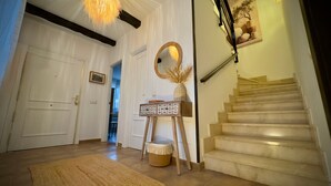 Un corridoio con una panca in legno, uno specchio e una scala.