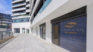 A modern building with a sign for 'CP APARTMENTS SAN MAMES' and a tiled walkway. - CP Apartments Bilbao (Bilbao)