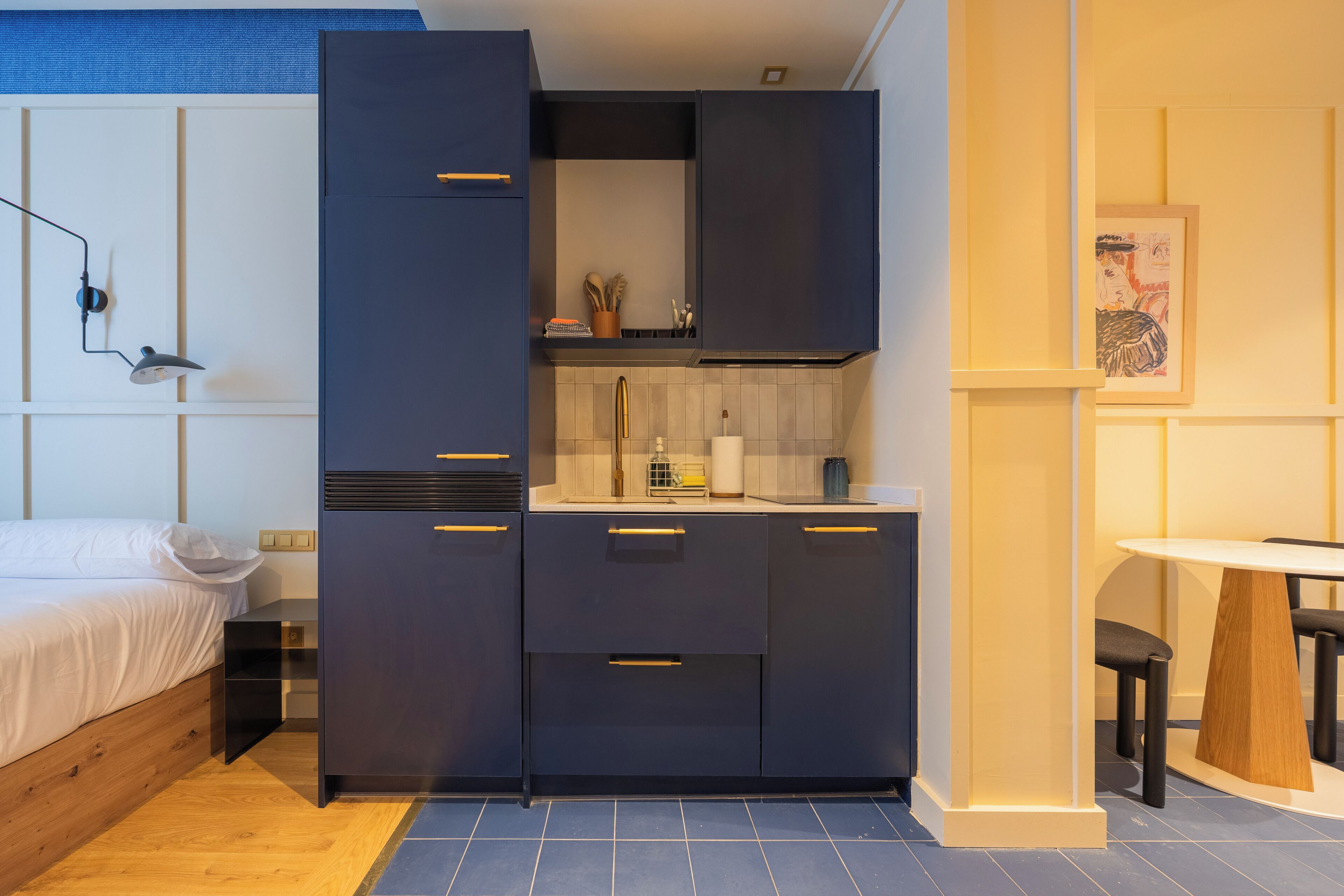 A compact kitchen with dark cabinets, a countertop, and a small dining area.