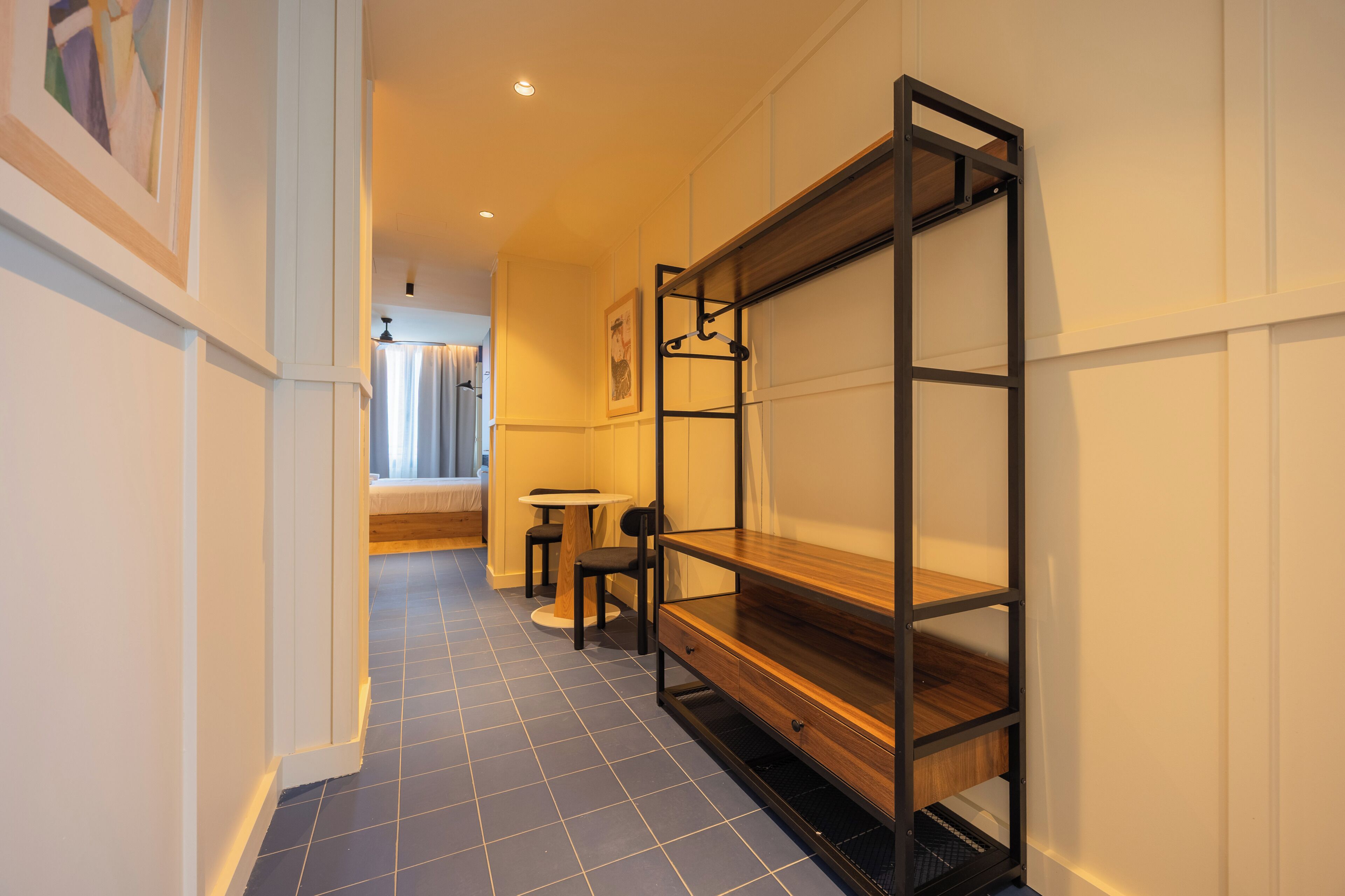 A hallway with a bunk bed, a small round table, and a chair.