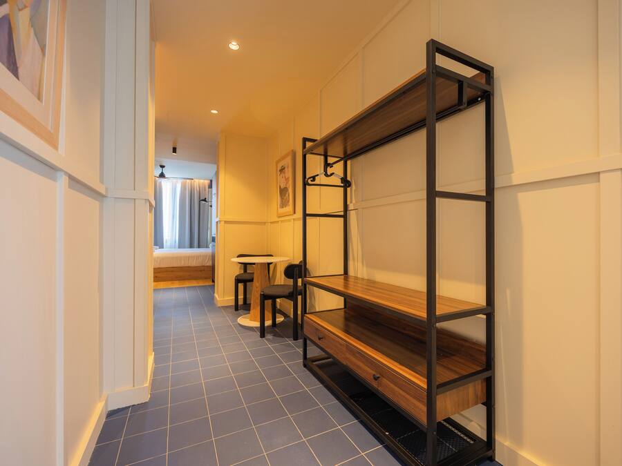 A hallway with a bunk bed, a small round table, and a chair.