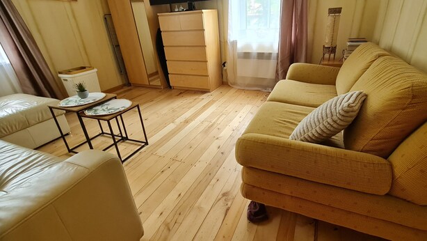 Un salon comprenant un canapé, une petite table, un fauteuil et un meuble.