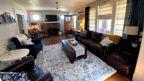 Ein Wohnzimmer mit Kamin, Sofas, Couchtisch und Fernseher.