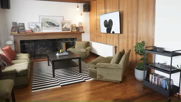 Ein Wohnzimmer mit Kamin, zwei Sofas, einem Couchtisch und einem Bücherregal.