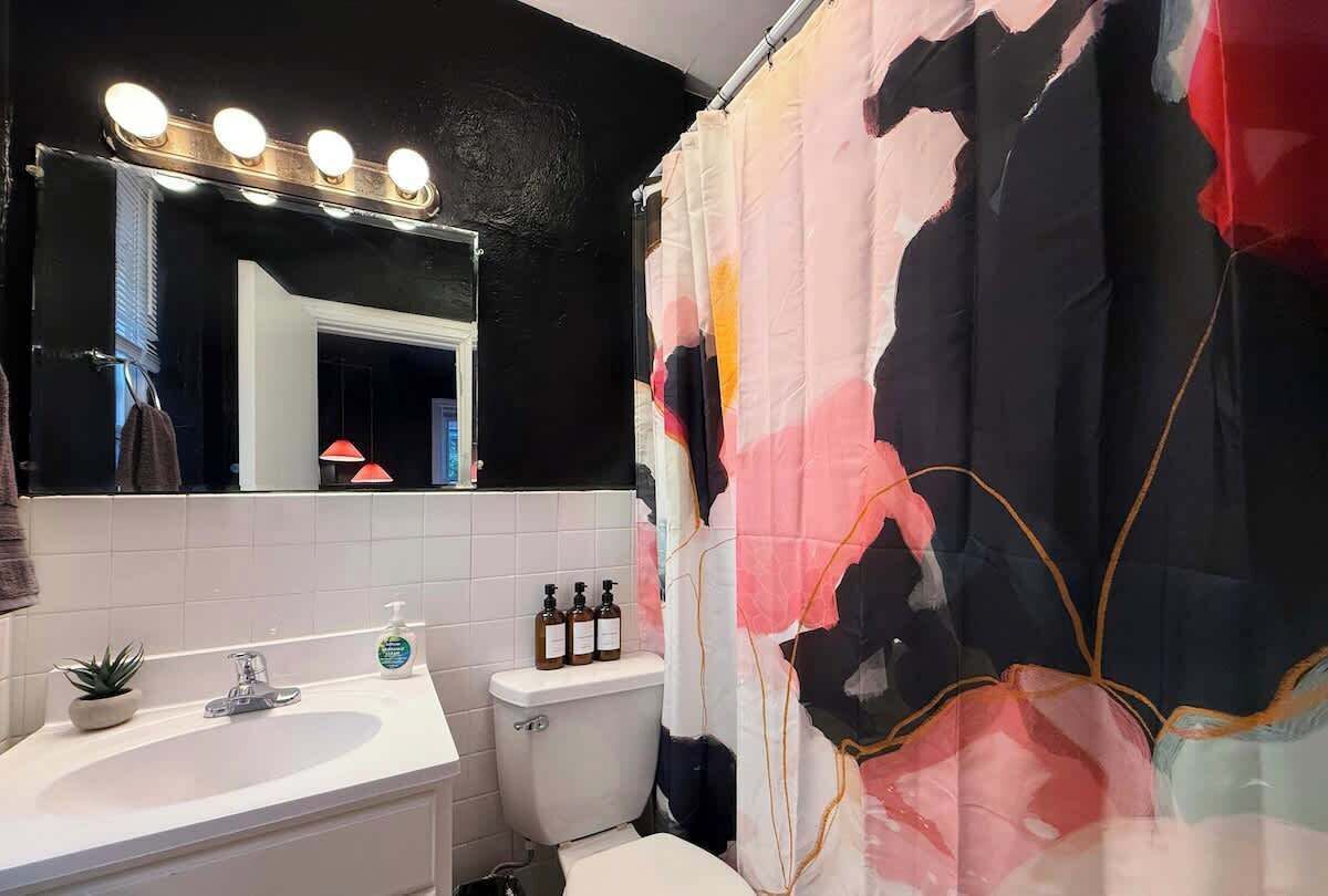 A bathroom with a sink, mirror, and toilet.