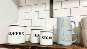 Kitchen storage containers labeled 'COFFEE,' 'TEA,' and 'SUGAR' on a shelf. - FIFA Walkable King Bed 3 Beds (Philadelphia)