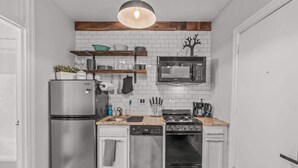 A compact kitchen with a stainless steel refrigerator, a microwave, a dishwasher, and a gas stove. - Huge Desk - Central - Soak Tub - Walkscore 98 (Philadelphia)