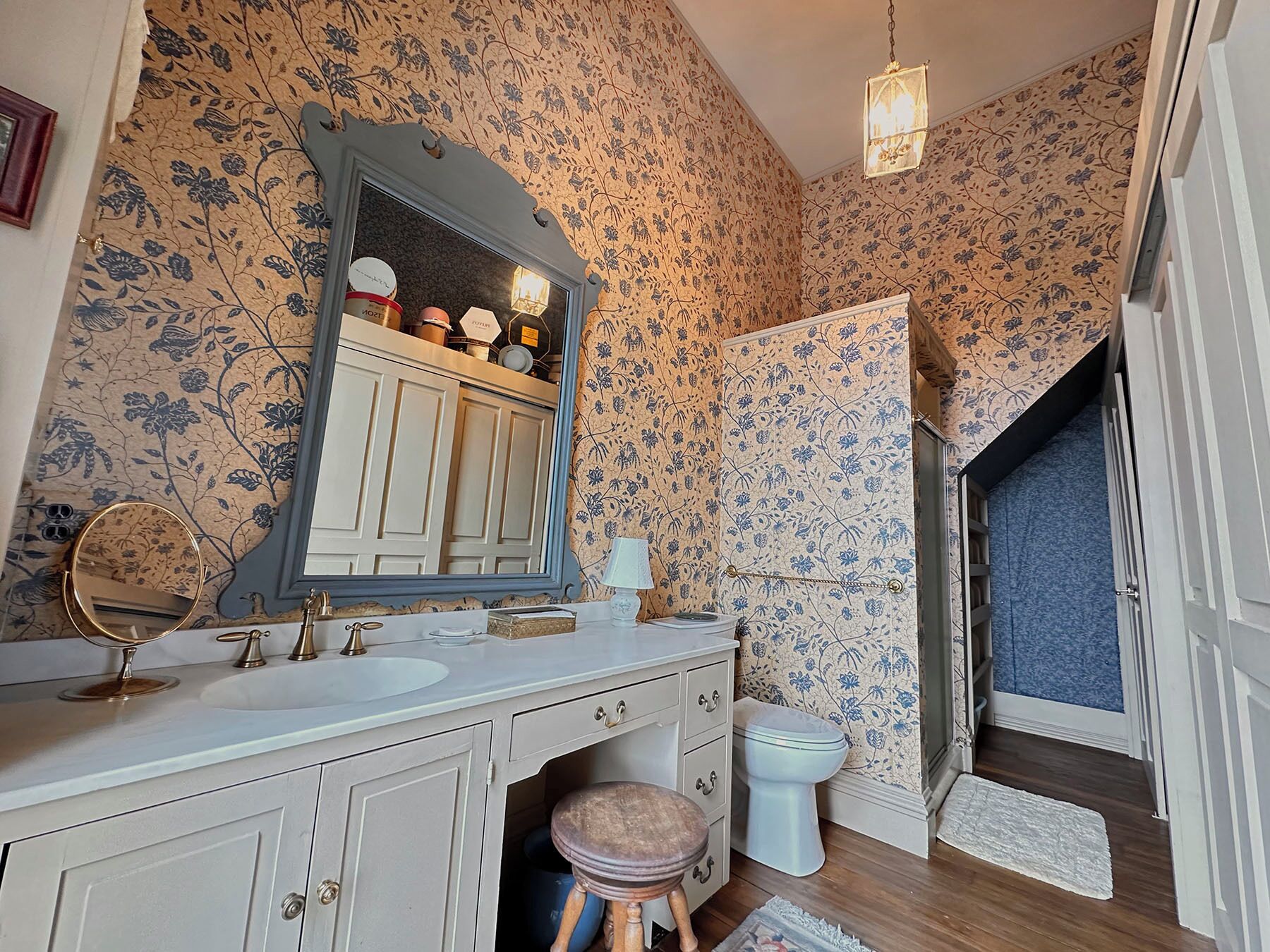 Un baño con lavamanos doble, espejo, inodoro y zona de ducha.