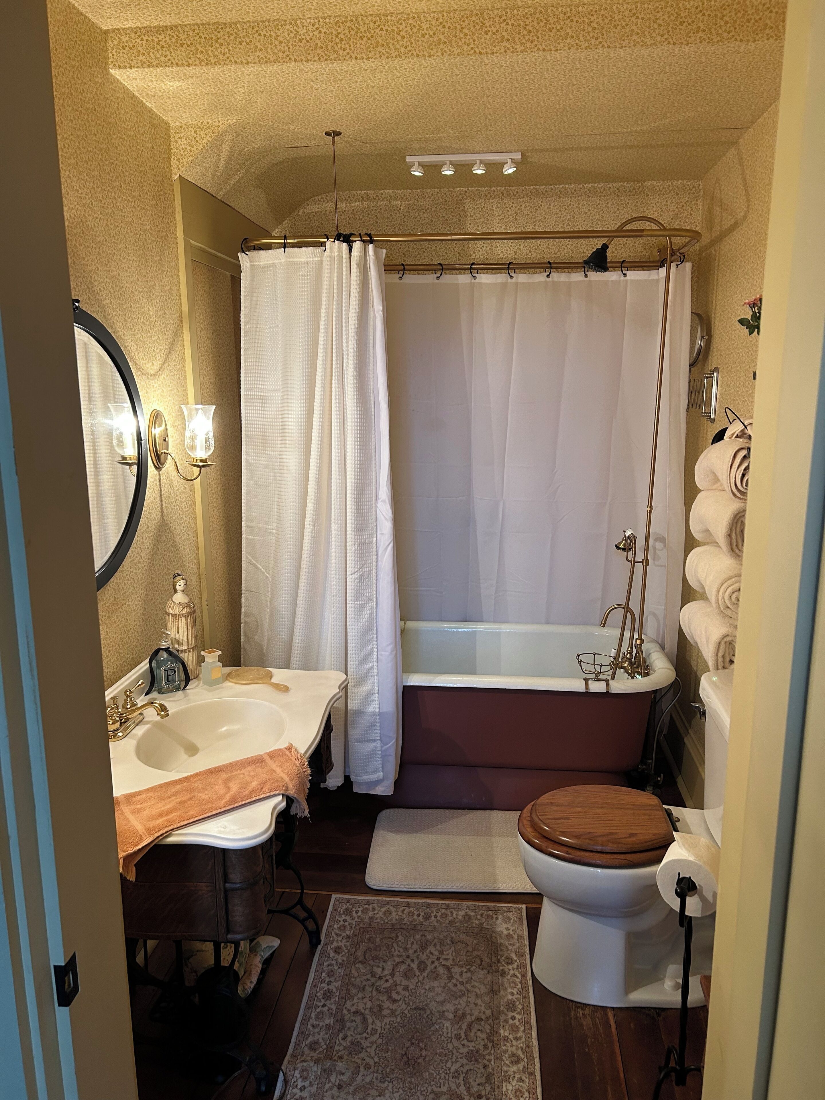 A bathroom with a bathtub, a toilet, a sink, and a mirror.