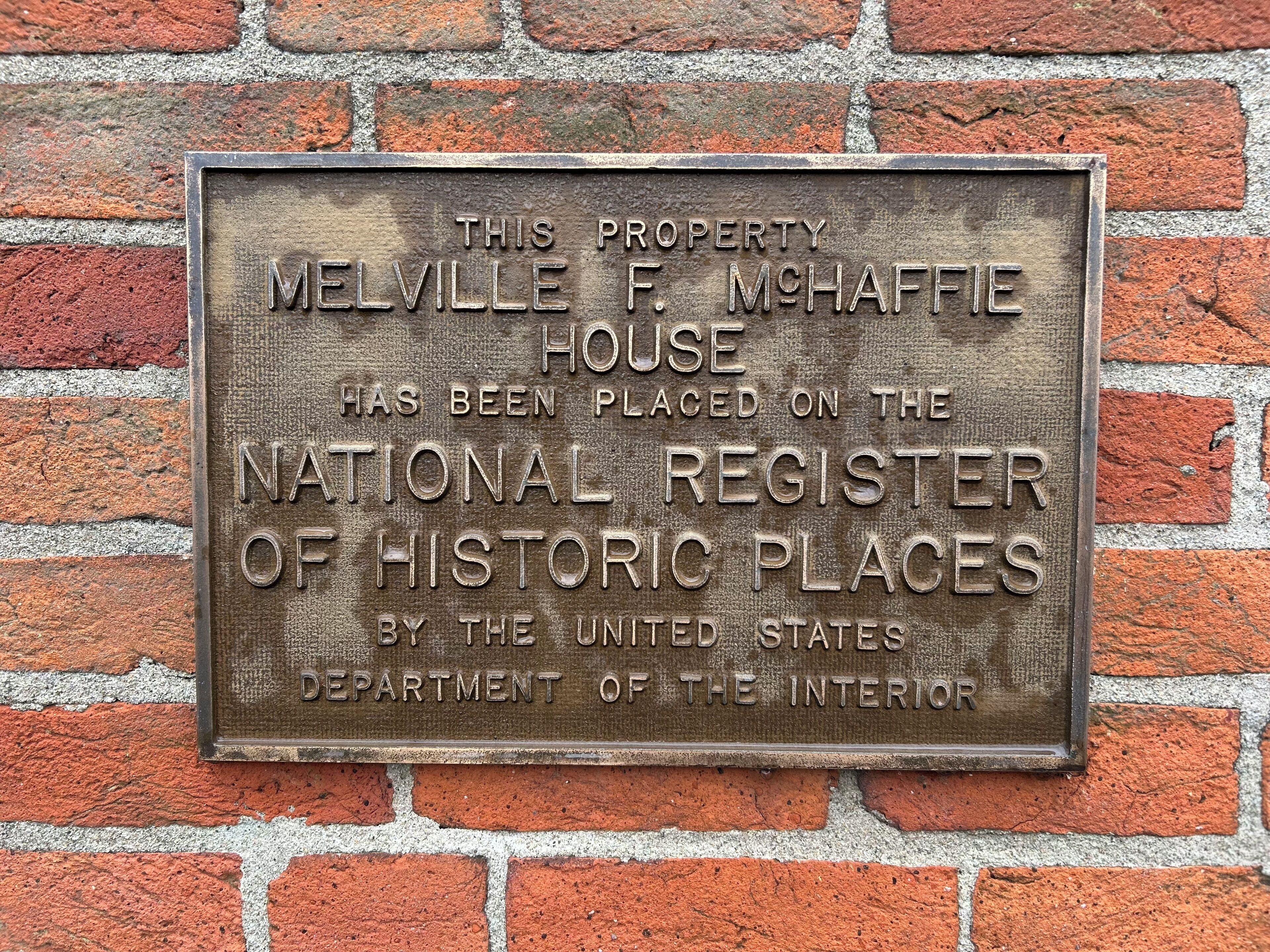 A plaque on a brick wall.