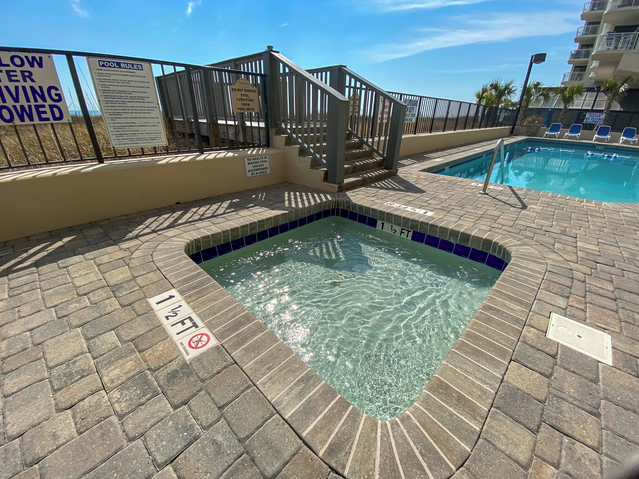 A swimming pool area with a shallow end marked '1 1/2 FT' and a no diving sign.