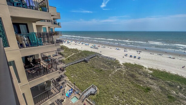 A multi-story hotel with balconies overlooking a beach. - 20% off week of July 25-Aug. 1.  3BR OF condo. Ocean Drive. Pool. (North Myrtle Beach)