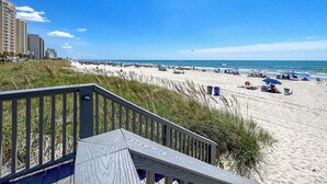 A beach with a wooden walkway leading to the shore, sandy beach, and ocean. - 20% off week of July 25-Aug. 1.  3BR OF condo. Ocean Drive. Pool. (North Myrtle Beach)