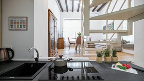 Una cocina moderna con un lavamanos, estufa y comedor con mesa y sillas.