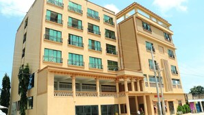 Un hotel de varios pisos con balcones, ventanas amplias y una entrada principal.