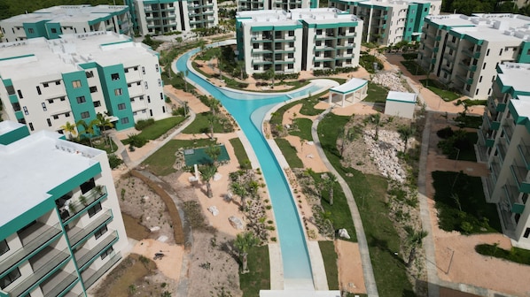 A residential complex with multiple apartment buildings, a central swimming pool, and landscaped gardens. - Modern Comfort in Serena Village Your Punta Cana Retreat (Punta Cana)