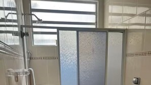 Kylpyhuone, jossa on suihku, wc ja ikkuna.