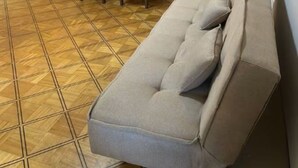 Ruokailutila, jossa on pöytä ja tuolit, sohva sekä valaisin.