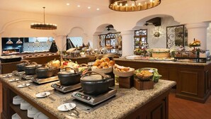 A buffet setup with multiple serving stations, a variety of food items, and a modern kitchen design. - 2 BEDROOM MASTER SUITE IN HACIENDA DEL MAR LOS CABOS (Colonia del Sol)