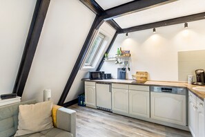 A kitchen with white cabinets, a microwave, and a coffee maker.