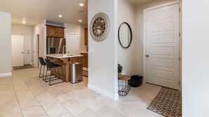 A modern kitchen with a central island, bar stools, a stainless steel refrigerator, and a built-in oven. - Spacious Getaway w/Heated Pool (Washington)