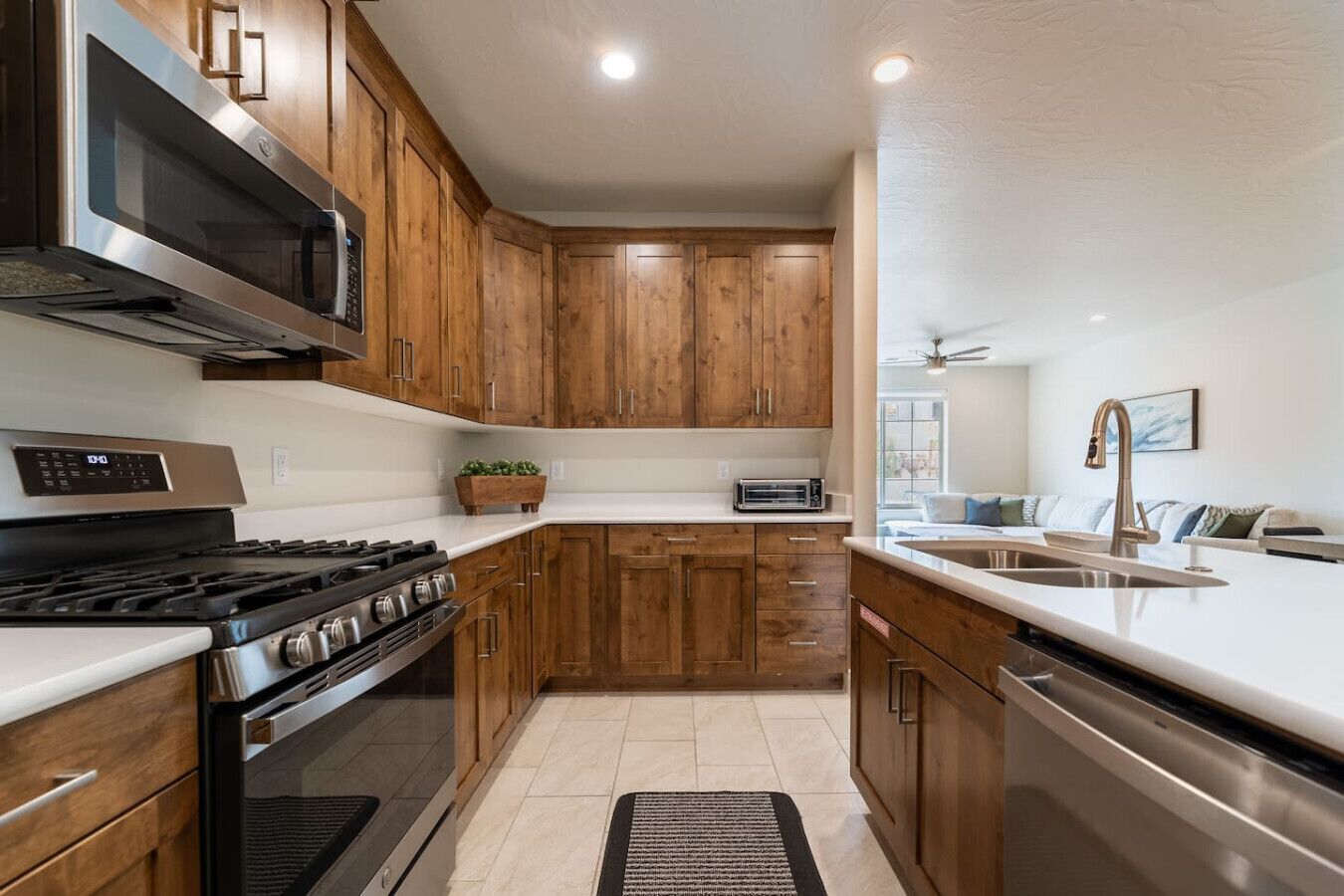A modern kitchen with wooden cabinets, stainless steel appliances, and a built-in oven.