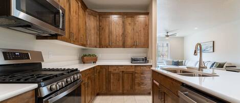 A modern kitchen with wooden cabinets, stainless steel appliances, and a built-in oven.