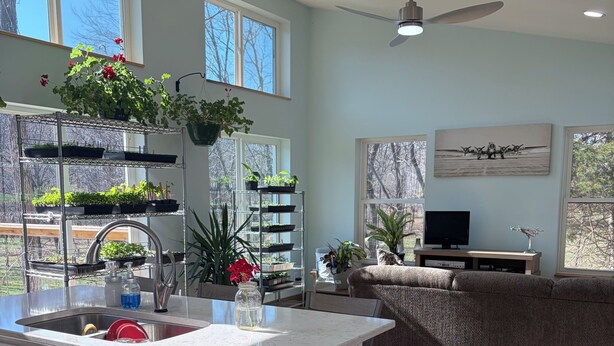 Une cuisine moderne dotée d’un îlot central, d’un coin repas avec un canapé et d’un ventilateur de plafond.