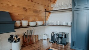 Una cocina con armarios de madera, cafetera, tostadora y diversos utensilios.