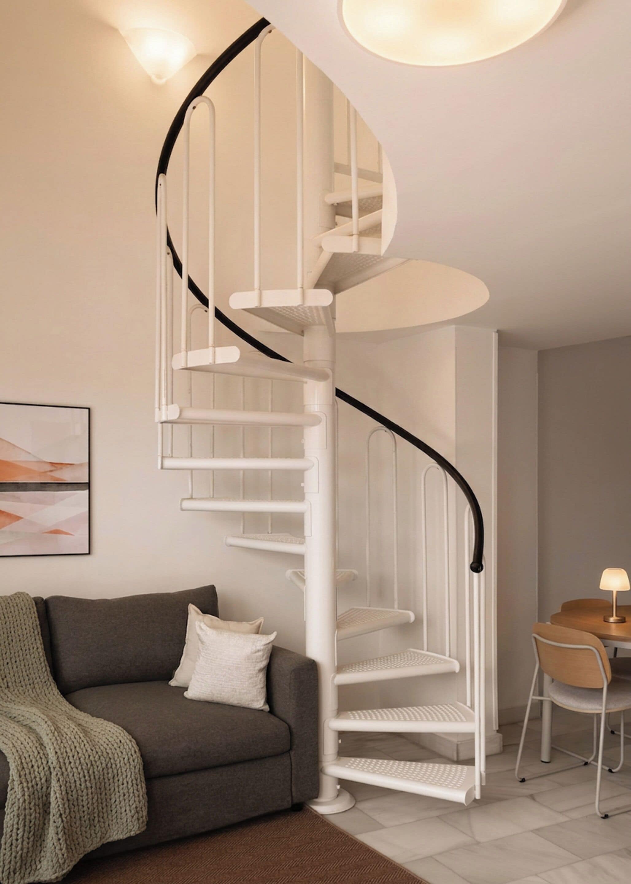 A modern interior with a spiral staircase, a grey sofa, and a small dining area.
