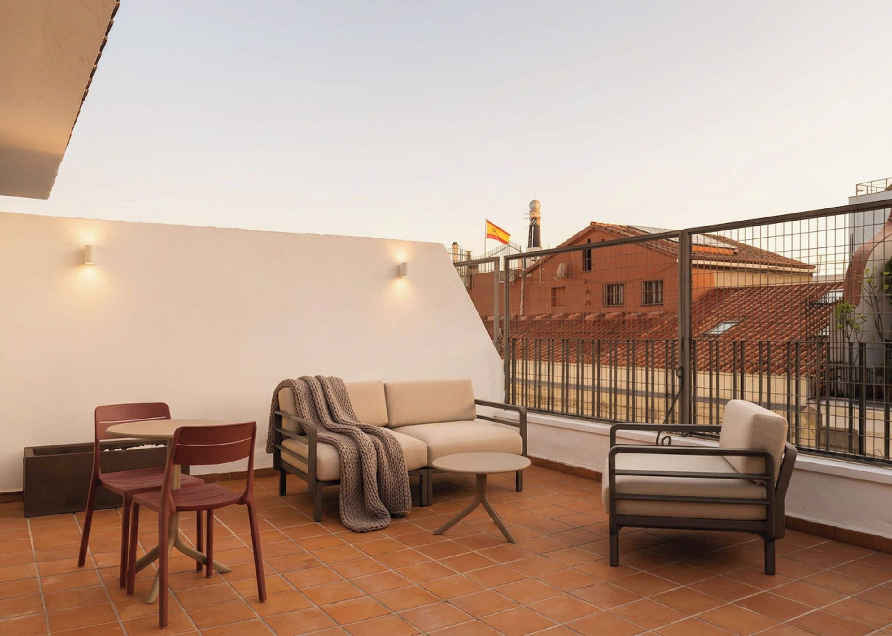 A terrace with a sofa, chairs, and a table.