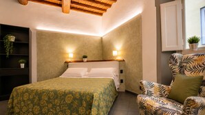 Ein Schlafzimmer mit einem Bett, einem Sessel, einem Regal mit Pflanzen und einem Fenster.