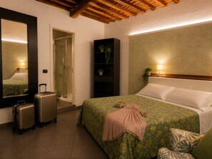 Ein Hotelzimmer mit einem Bett, einem Spiegel, einem Kleiderschrank, einem Nachttisch mit Lampe und zwei Koffer.
