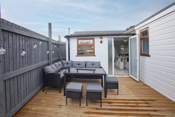 A patio with a sofa set, a table, and chairs.