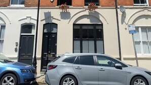 A two-story building with a black front door, windows, and a satellite dish. - Spacious 4-Bedroom Victorian Townhouse | Sleeps 8 | Central London (E1) (London)