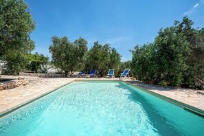 A rectangular swimming pool with clear blue water, surrounded by stone tiles and trees. - Torrette di Ostuni – Private Villa with Pool near Ostuni (Ostuni)