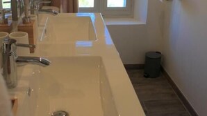A bathroom with two sinks, a window with curtains, a mirror, and a trash can. - La Maison de Vaison (Vaison-la-Romaine)