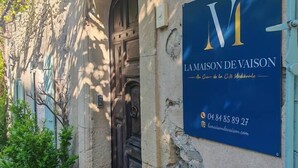 Ein Gebäude mit einem Schild für 'Lamaison de Vaison' und der Nummer 16 über der Tür.