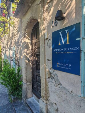 Un bâtiment avec une enseigne indiquant « La Maison de Vaison » et le numéro « 16 » au-dessus de la porte.